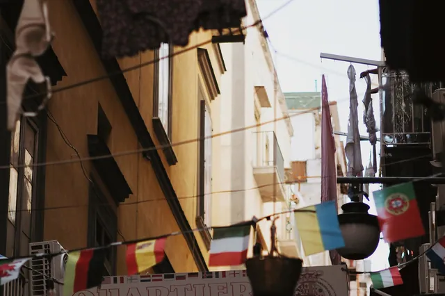 A narrow street in the Quartieri Spagnoli of Naples, strung with laundry and small flags.